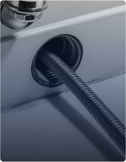 Plumber cleaning a clogged bathroom drain