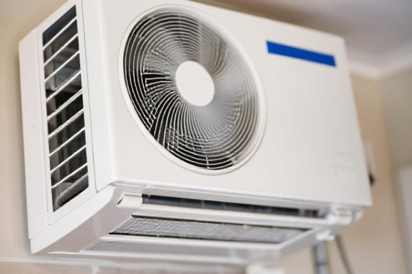 Technician performing a quality check on an air conditioning unit after installation. The image shows a close-up of refrigerant gauges and thermostat calibration.